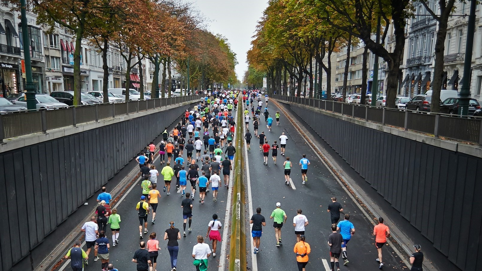 Hardlopers tijdens een stadsmarathon, met zicht op uitrusting en diverse loopkleding