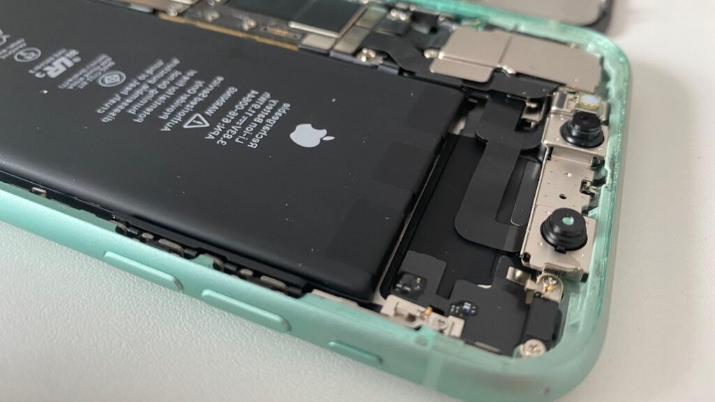 Smartphone met open behuizing waarin de batterij zichtbaar is, tijdens het proces van batterij vervangen.
