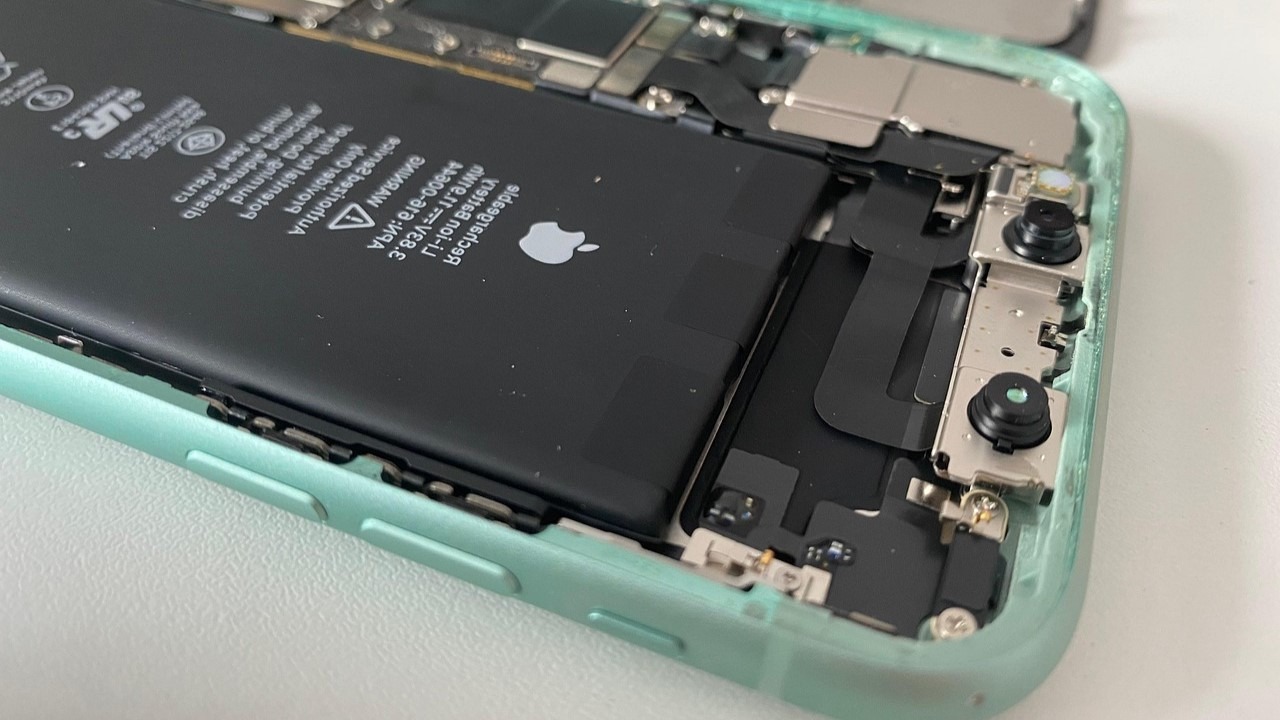 Smartphone met open behuizing waarin de batterij zichtbaar is, tijdens het proces van batterij vervangen.