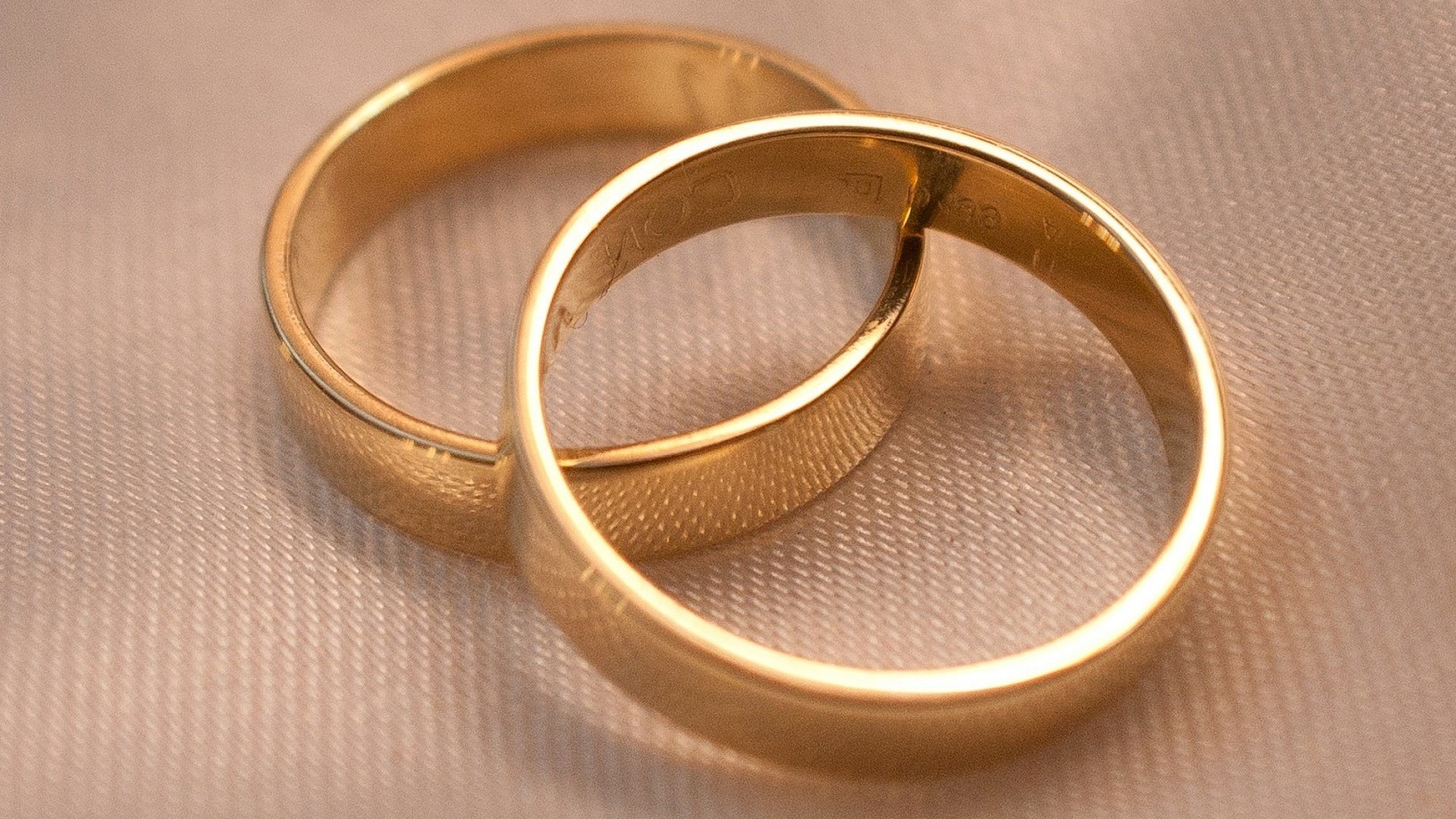 twee gouden trouwringen als symbool voor het huwelijk en de kosten van een scheiding
