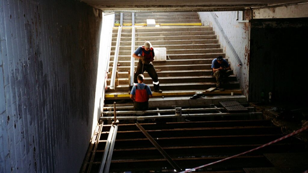 Traprenovatie in uitvoering met vakmensen bezig aan een betonnen trapconstructie