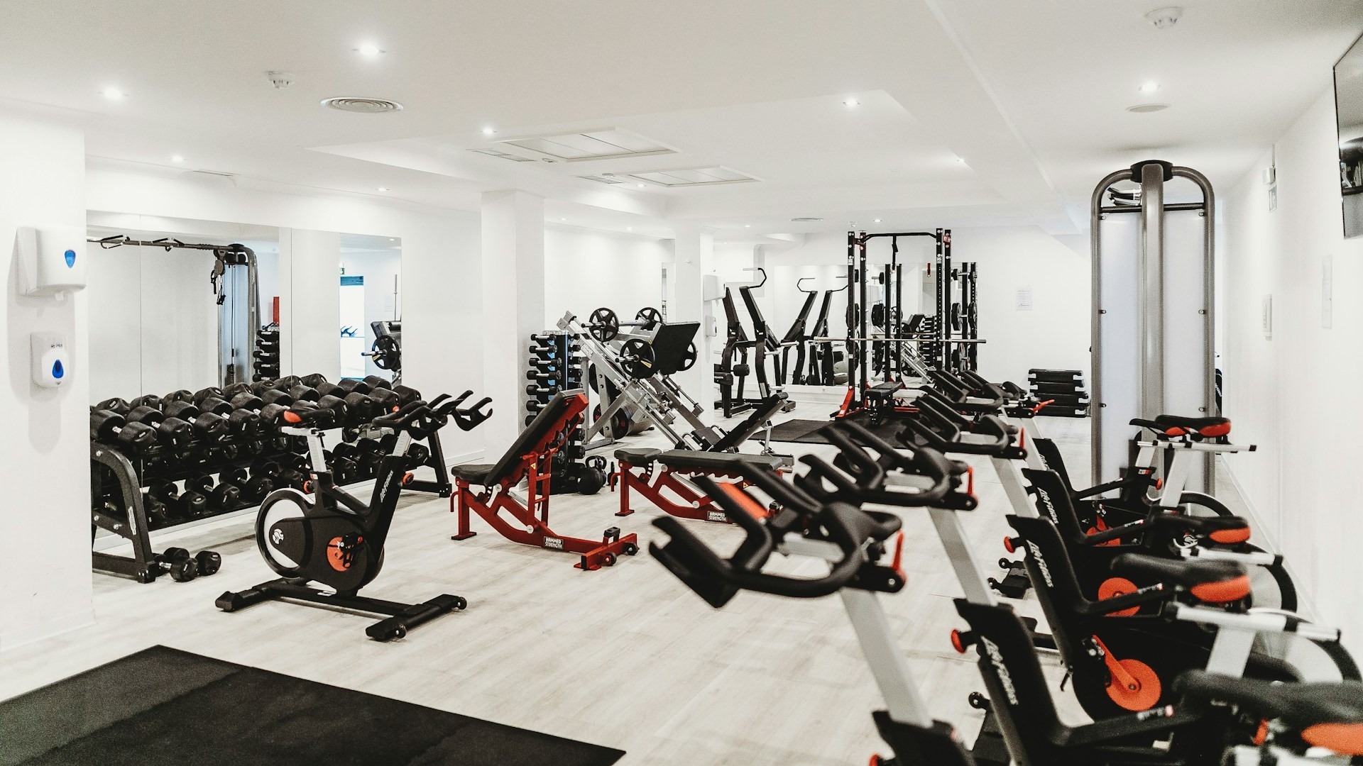 Lichte trainingsruimte met cardio- en krachttoestellen, passend bij onderhoudskosten fitnessapparatuur