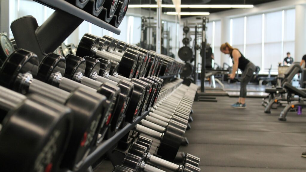 Dumbbellrek in sportschool met halters en krachttoestellen voor onderhoud van fitnessapparatuur