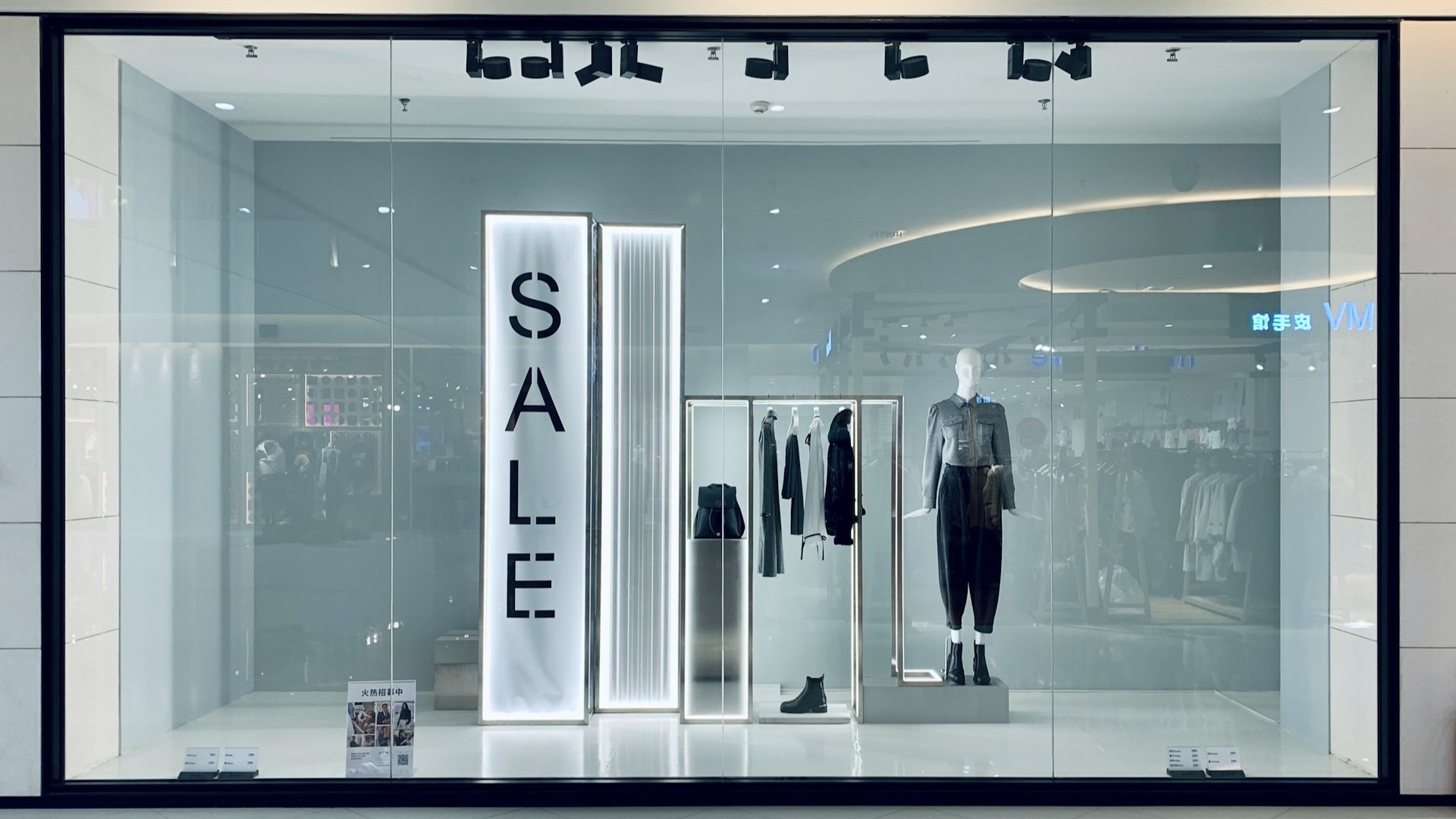 Minimalistische etalage met mannequin en verlichting, passend bij kosten etalage kledingwinkel en stylingconcept