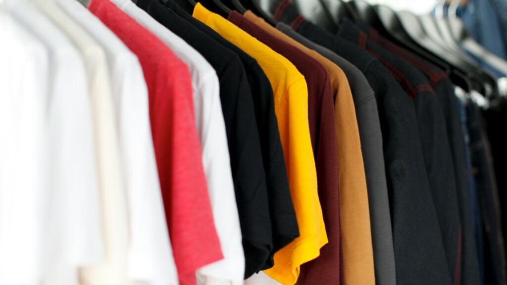 Kledingrekken met kleurrijke shirts in winkel, voorbeeld van kosten etalage kledingwinkel en presentatiekeuzes