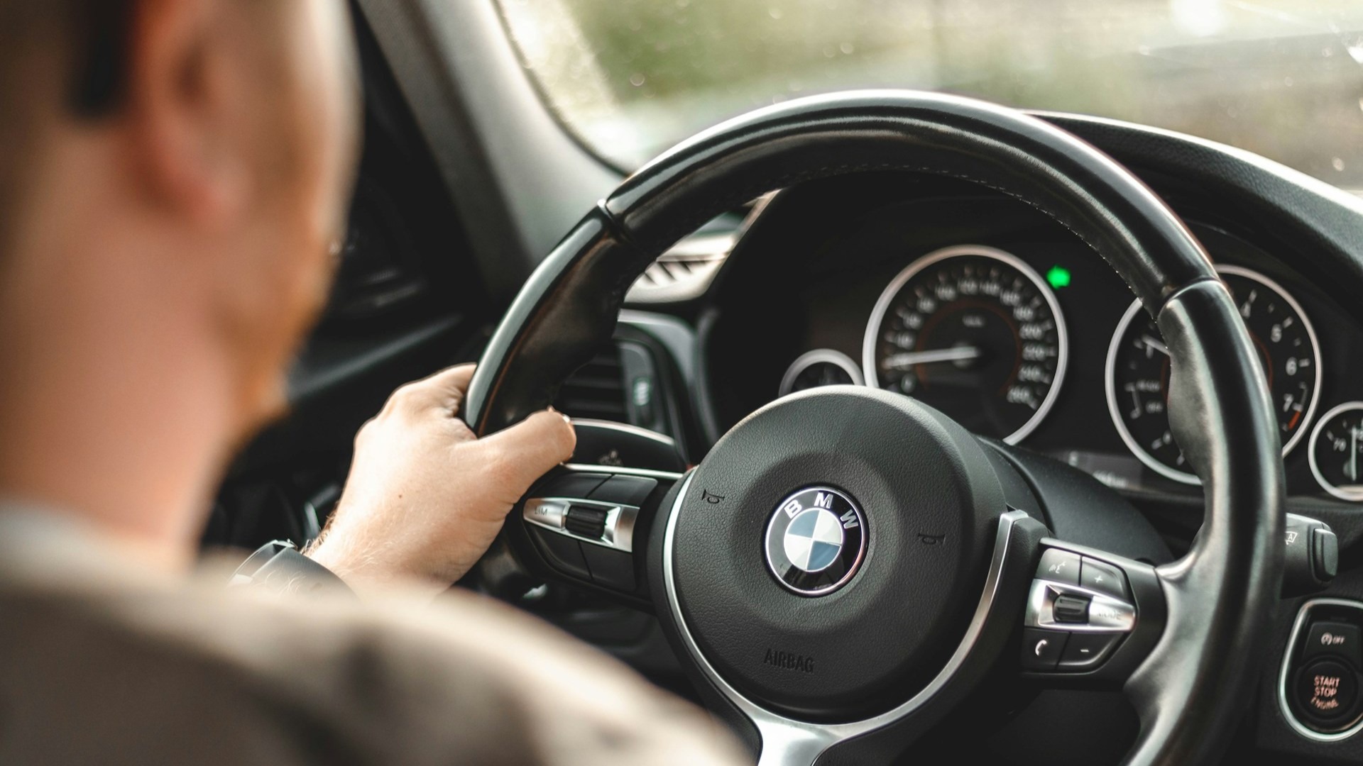 Man achter het stuur van een auto na het behalen van zijn rijbewijs